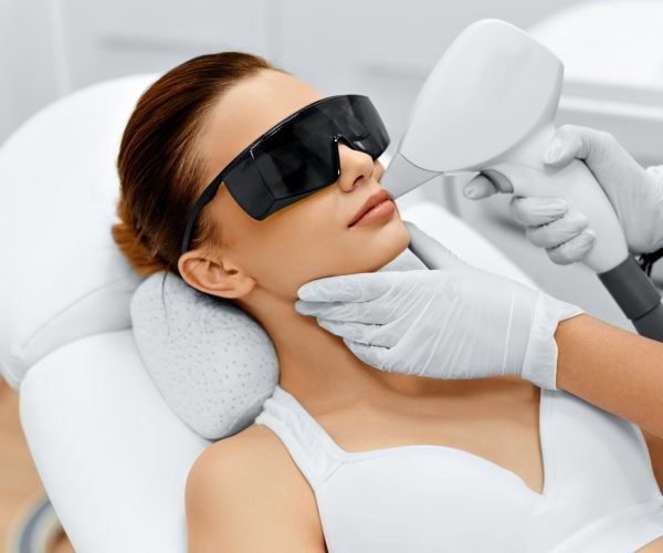 Face Care. Facial Laser Hair Removal. Beautician Giving Laser Epilation Treatment To Young Woman's Face At Beauty Clinic. Body Care. Hairless Smooth And Soft Skin. Health And Beauty Concept.